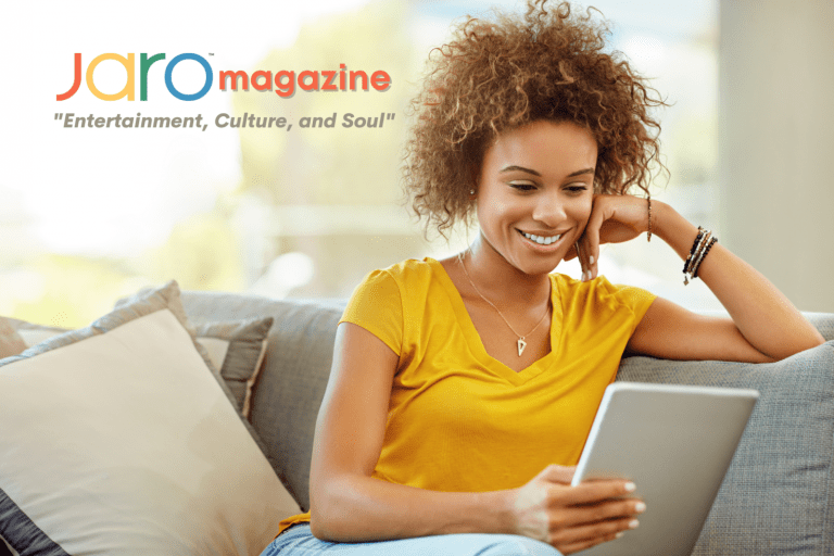 Woman smiling while reading a tablet for JARO Magazine.